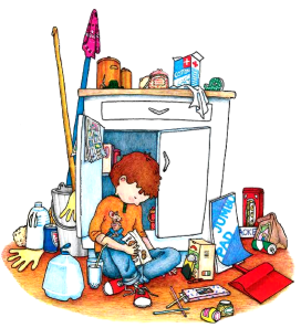 A boy sits on the floor amidst clutter mops, brooms, paper, glue, and more, holding a small mouse and a box of cookies.
